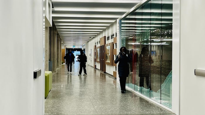 Des étudiants marchent dans un corridor.