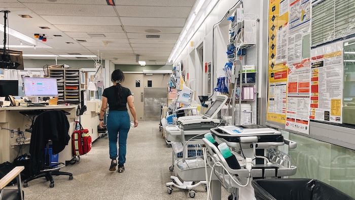 Une employée du CISSS de la Côte-Nord se déplace à l'urgence de l'hôpital régional de Sept-Îles. Elle est entourée de machines, de civières et de bureaux.