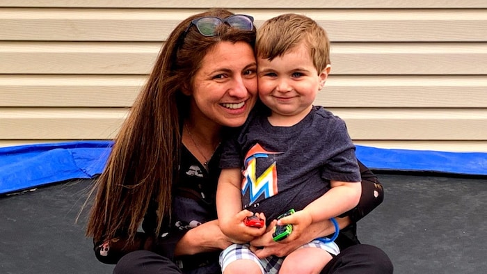Julie Léger tient son fils assis sur un trampoline.