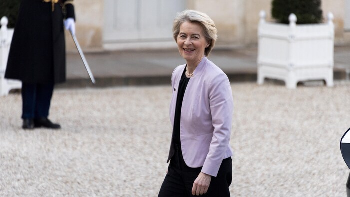 La présidente de la Commission européenne, Ursula von der Leyen, sourit aux photographes.