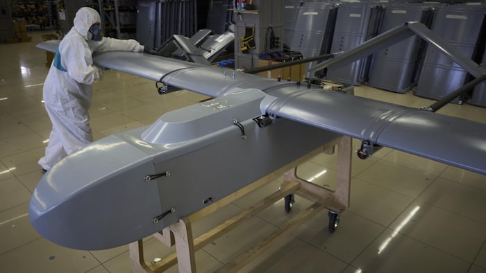 Un travailleur assemble un drone dans une usine.