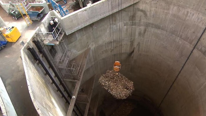 Une grue équipée d'un tamis récupère les gros déchets des égouts.