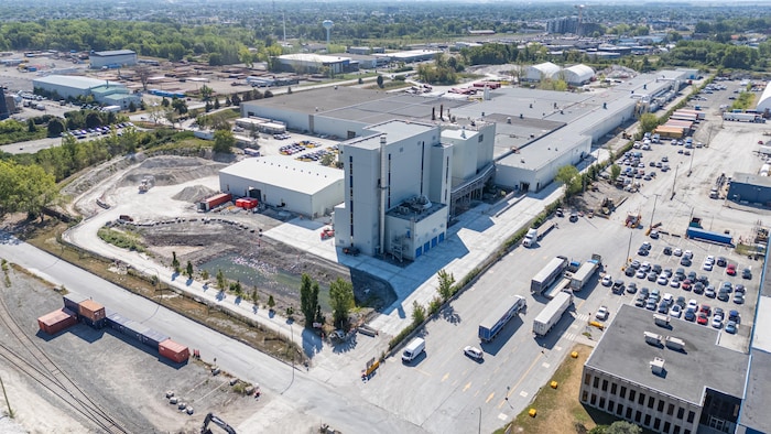 Une usine vue du ciel avec des tours et des camions stationnés.