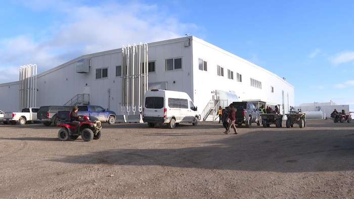 Des véhicules sont garés devant l'usine de maisons préfabriquées à Arviat.