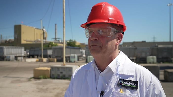 Terry Finn, portant un casque et un uniforme de Sanimax, en entrevue à l'extérieur.