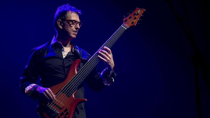 Le bassiste en prestation sur scène. 