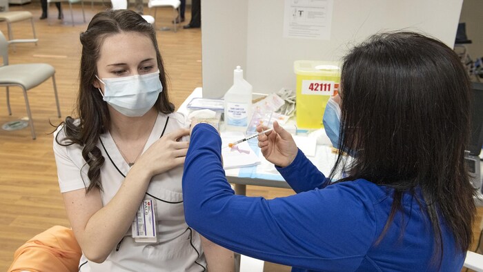Une infirmière reçoit un vaccin.