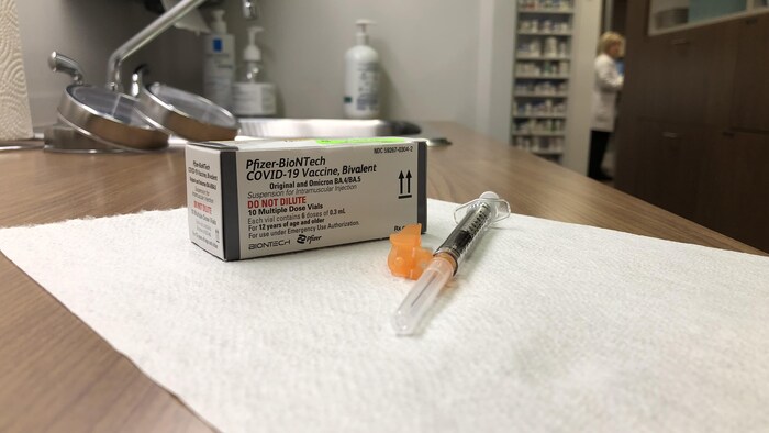 Un boîte de vaccin et une seringue sur un comptoir.