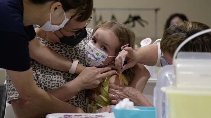 Une enfant de 3 ans reçoit son vaccin contre la COVID-19 au centre commercial Victoria Square Mall à Regina, en Saskatchewan, le 22 juillet 2022.