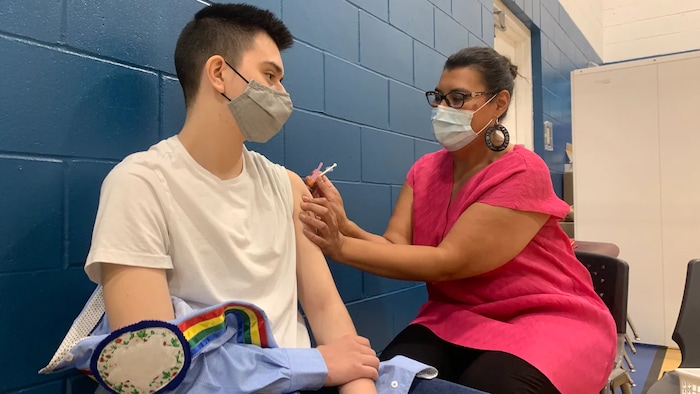 En la foto, Marcia Anderson aplica la vacuna a un joven indígena contra el coronavirus en el centro de salud Ma Mawi Wi Chi Itata de Winnipeg, en Manitoba.