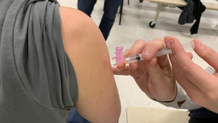 Gros plan sur le bras d'une personne qui se fait vacciner.