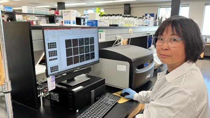 Yan Zhou devant un ordinateur dans un laboratoire.