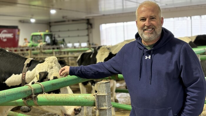 Daniel Gobeil flatte la tête d'une vache.