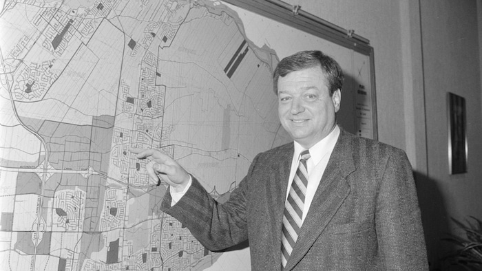 Gilles Vaillancourt devant une carte de la ville de Laval.