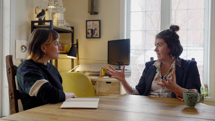 La chercheuse Valérie Langlois est assise à la table de sa salle à manger, face à la journaliste Marianne Desautels-Marissal, qui l'écoute répondre à ses questions.