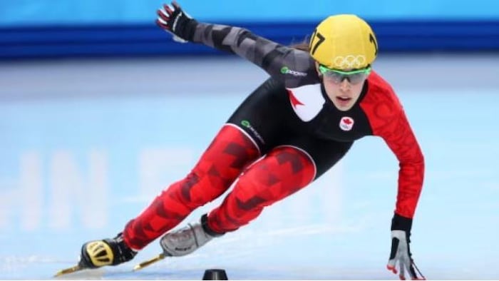 Elle pose la main gauche sur la glace dans un virage.