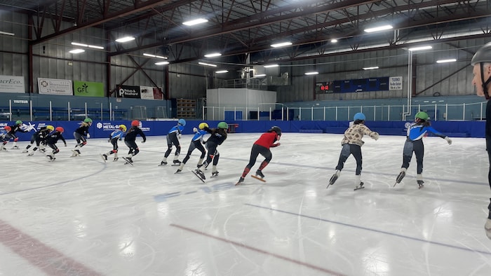 Valérie Maltais patine avec des jeunes.