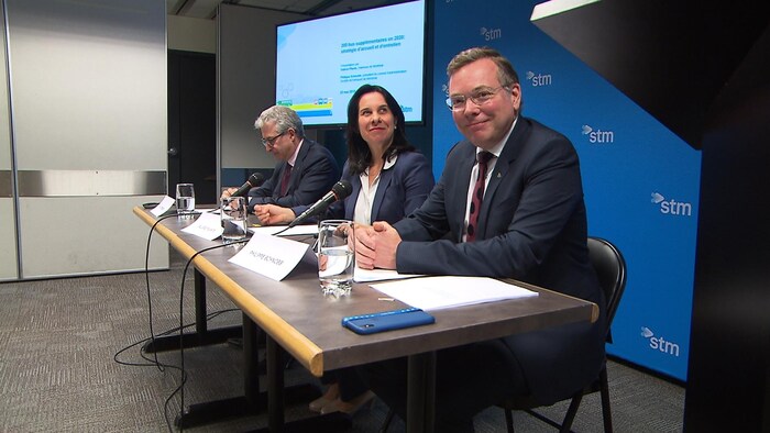 Les intervenants sont assis à une table, des micros devant eux.
