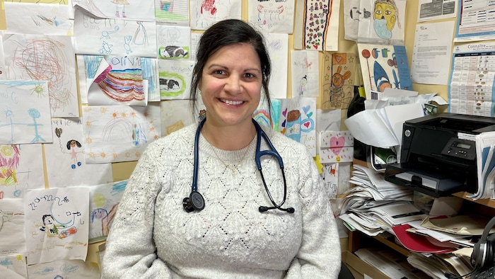 Valérie Therriault est assise à son bureau. Derrière elle, le mur est tapissé de dessins d'enfants.