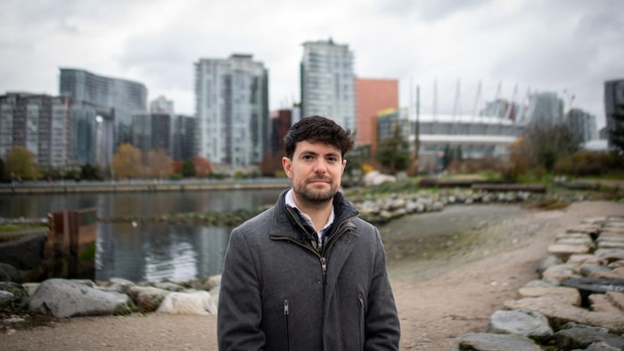 Mauricio Carvallo Aceves devant un bras de mer et des immeubles.