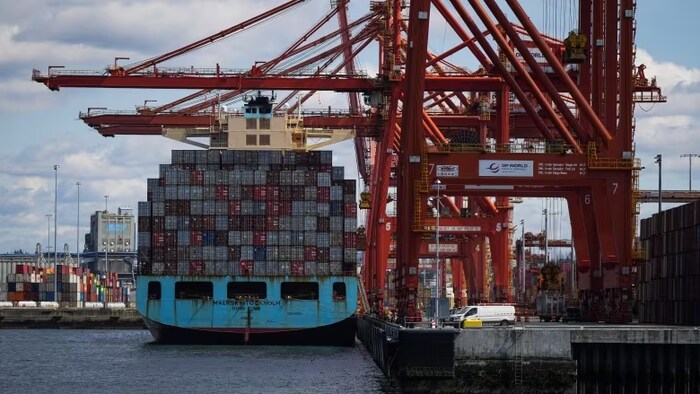 Des grues déchargent des conteneurs au port de Vancouver le mardi 25 avril 2023.