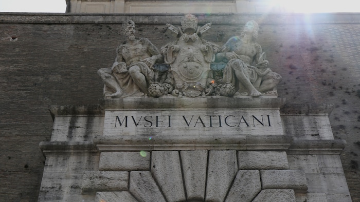 L'entrée du musée avec écrit en italien Musée Vatican et une sculpture.