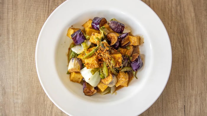 Vegan kare-kare tofu with eggplant and beans na nasa plato.