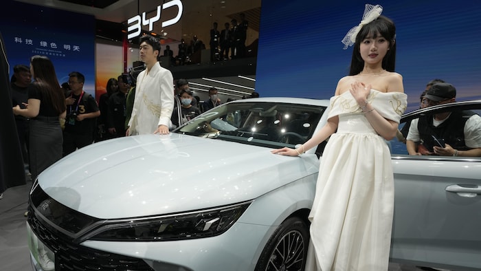 Electric cars: Is it a good idea to restore incentives? star-news.press/wp A man and woman on both sides of the vehicle in an exhibition hall.