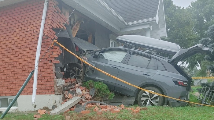 Une voiture encastrée dans une maison.