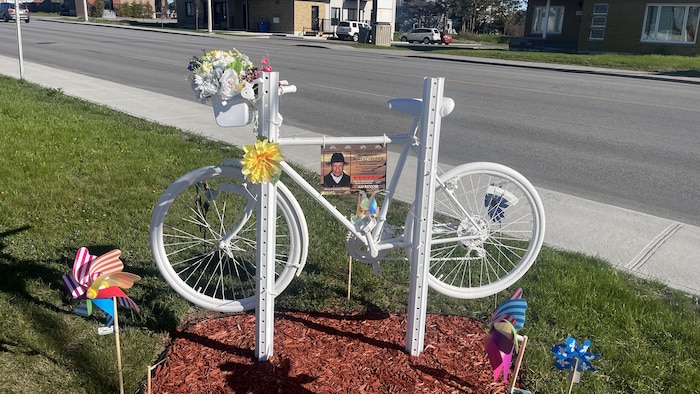 Un vélo fixé au sol près de la route.