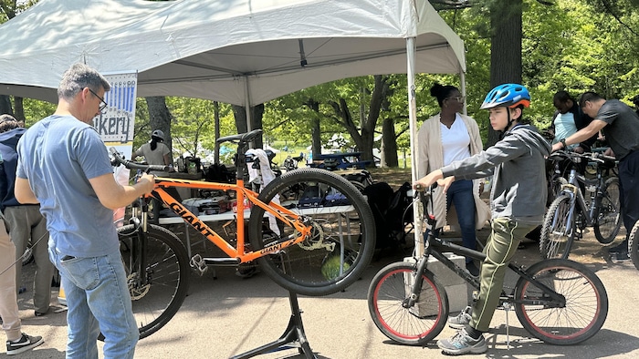 Des cyclistes rassemblés près d'un  kiosque extérieur.