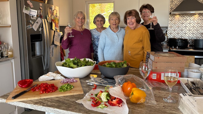 La mère et les tantes d'Annie Trépanier derrière le comptoir de cuisine.