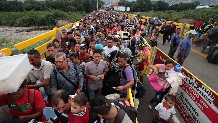 Une longue file de personnes attend sur le pont.