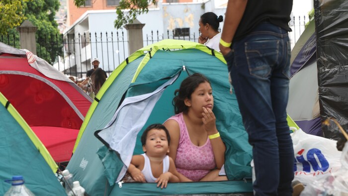 Des résidents d'un immeuble effondré vivent dans des tentes.