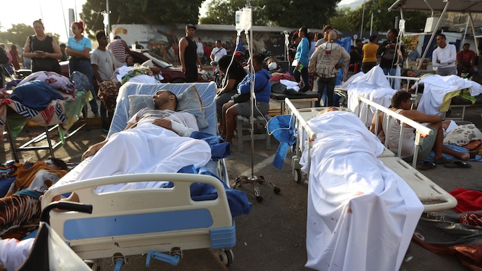 Des patients, dans leur lit d'hôpital, dehors