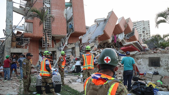 Des secouristes recherchent des victimes parmi les décombres d'un bâtiment effondré.
