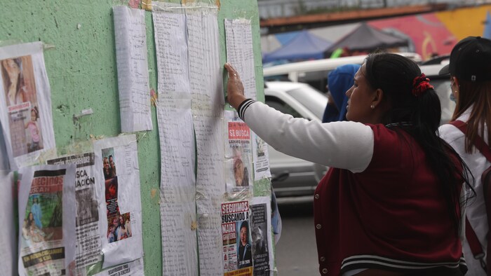 Une femme consulte les listes des hôpitaux à la recherche de proches après le double séisme au Venezuela.