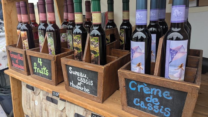 Des bouteilles de liqueurs sont dispersées sur une étagère dehors.
