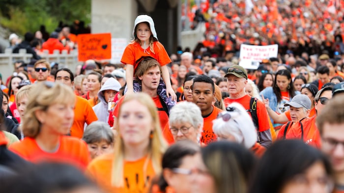 Une foule de personnes marchent.