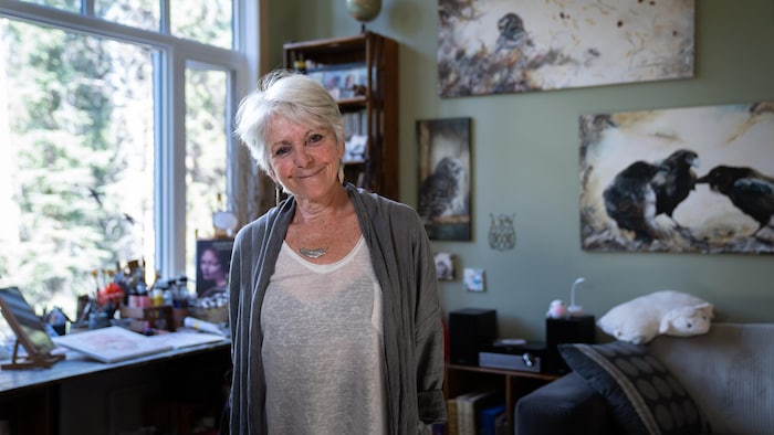 Véronique Bottaro sourit à l'objectif devant sa table de travail, dans son salon.