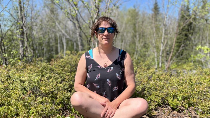 Une femme assise par terre.