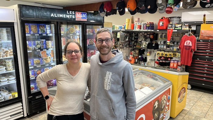 Une femme et un homme debout dans un magasin, souriant.