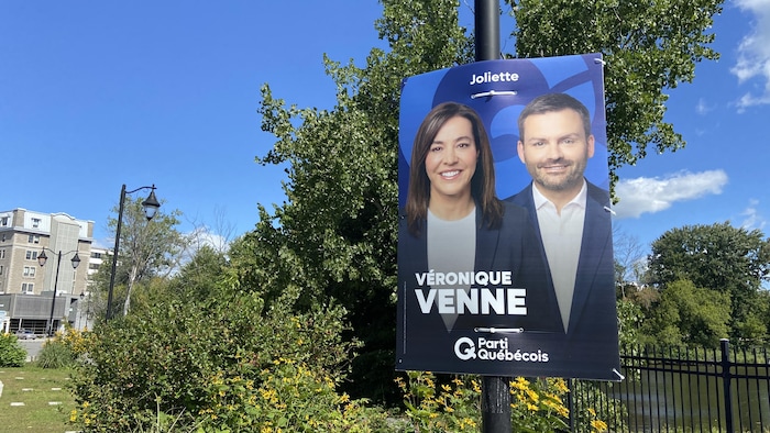 Une pancarte accrochée à un poteau dans un jardin.