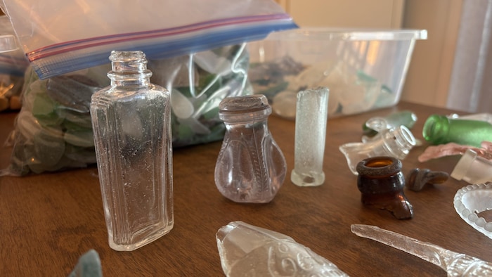 Gros plan détaillé sur plusieurs petits objets en verre posés sur une surface en bois.