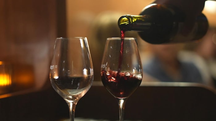 Deux verres sur une table sont remplis de vin.