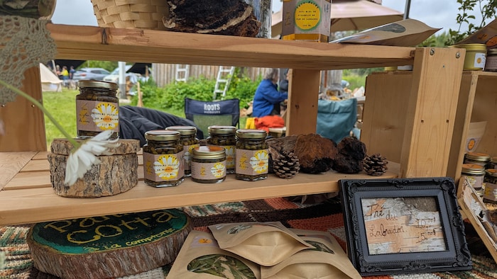 Des produits en pots et en sac en vente sur une table décorée.
