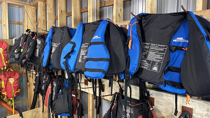 Des vestes de sauvetage accrochées au mur dans un espace de location.
