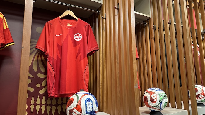 Un maillot rouge de l'équipe canadienne de soccer est suspendu dans un casier.