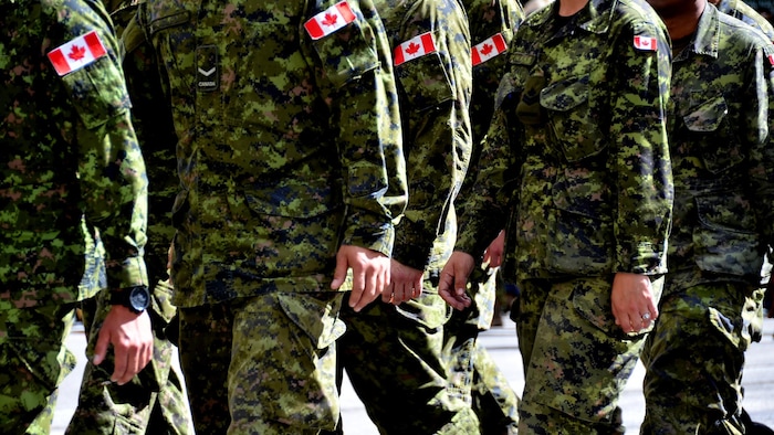 Des membres des Forces armées canadiennes qui marchent en uniforme.