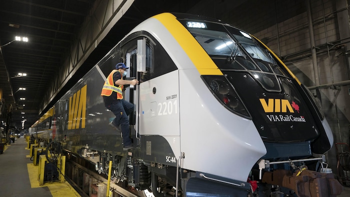 Un employé montant dans la locomotive d'un way de Via Rail Canada.